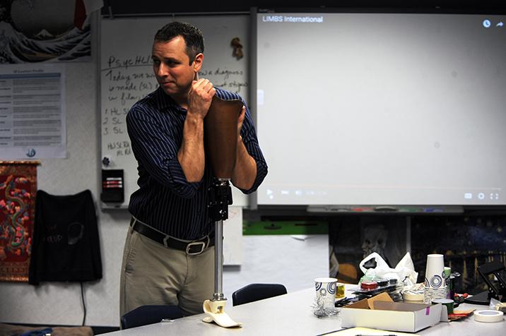 Bergman demonstrating the workings of a LIMBS prosthetic leg to students. 