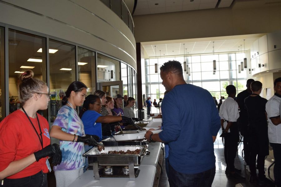 Blú students serve barbecue to staff members. 