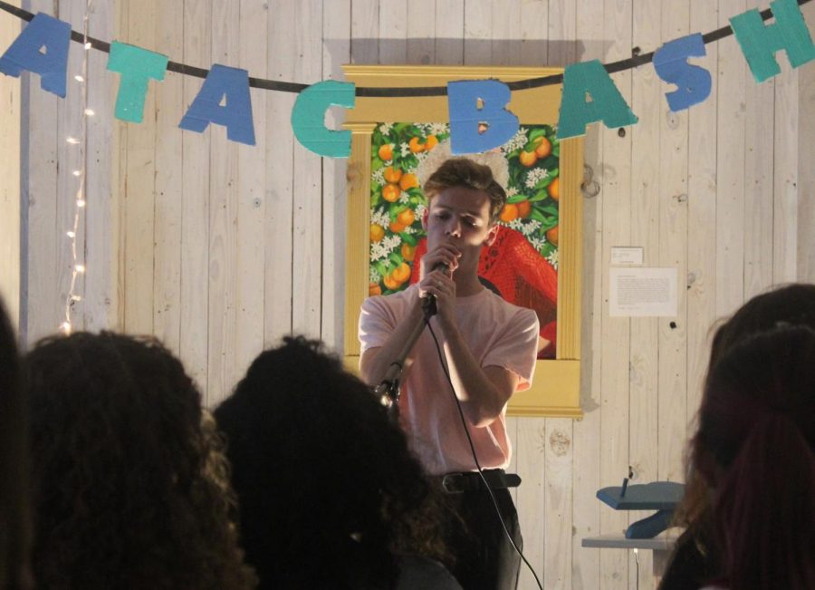 Senior Levi Reeves sings into his microphone as he performs in front of a crowd of fellow musicians at the August ATAC Bash. Performers display their musical skills at ATAC bashes and engage in an artistic community in the process.