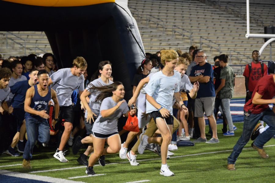 The swim team runs out to the field onto of the football stadium-. “I think the pep rally was a great idea”  Junior Ansh Chawla said. “A family event that brought a lot of sports teams together. I think it went really well.” All the sports teams ran out to the field to be cheered for by the community.