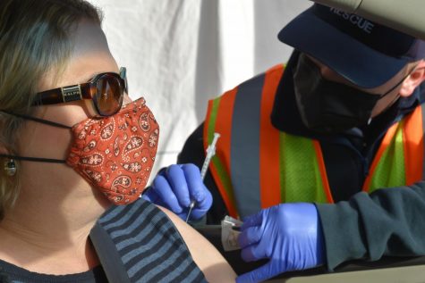 An Allen Fire Dept. paramedic vaccinates a woman in her car. 